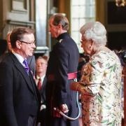 Mr Stewart receiving his MBE from the queen