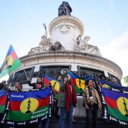 Demonstrators hold Kanak and Socialist National Liberation Front flags during a gathering in Paris on Thursday (Thomas Padilla/AP)